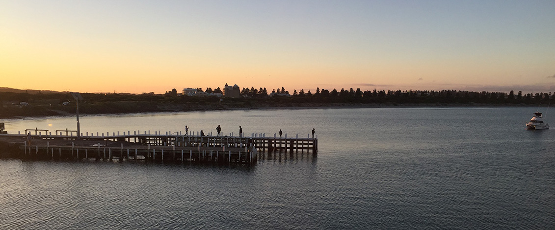The pier and calm waters of Lady Bay in Warrnambool at sunset.